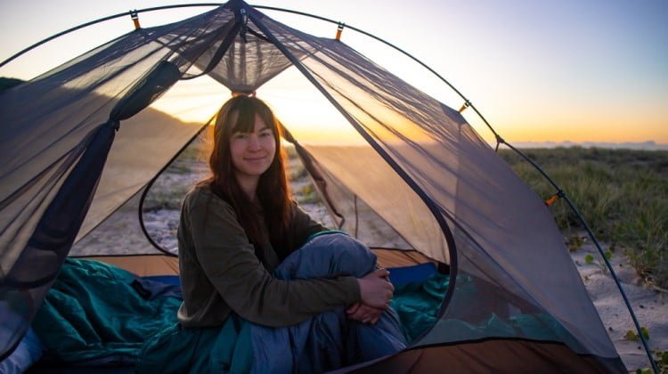 A girl camping in a tent with stargazing roof